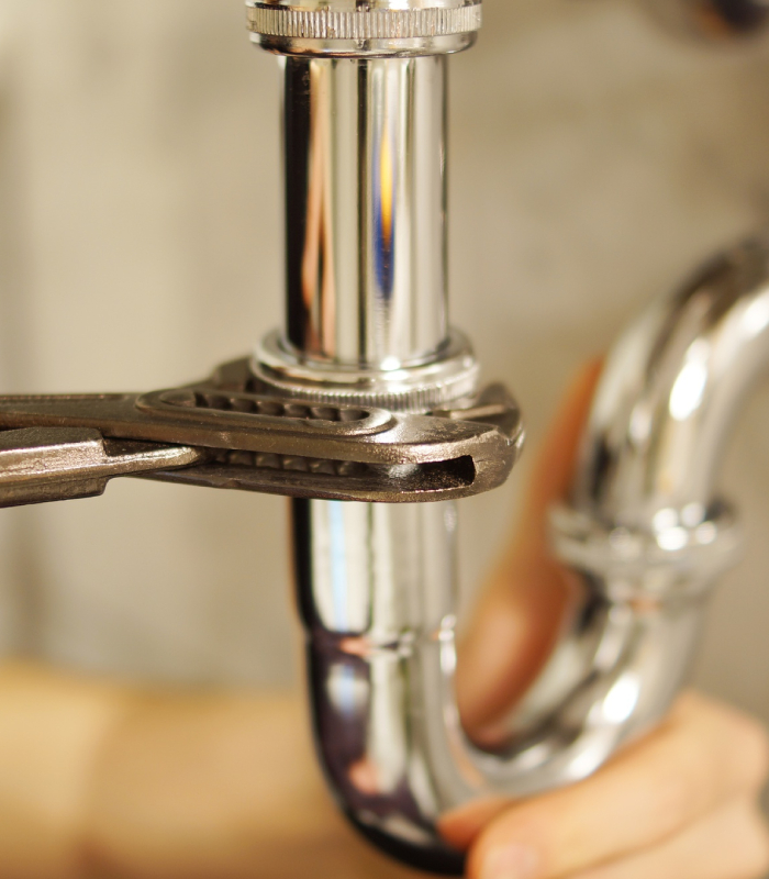 Réparation de siphon et raccordement plomberie Intervention sur siphon de lavabo avec clé pour des travaux de dépannage plomberie